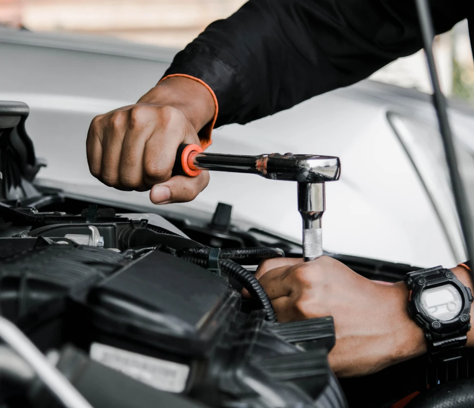 Hands fixing vehicle engine with tool