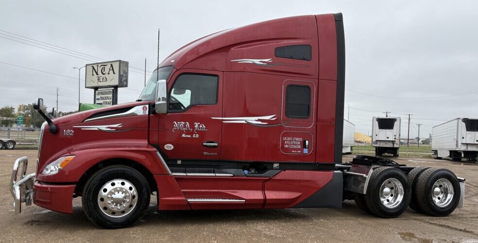 Red sleeper cab semi truck parked on lot